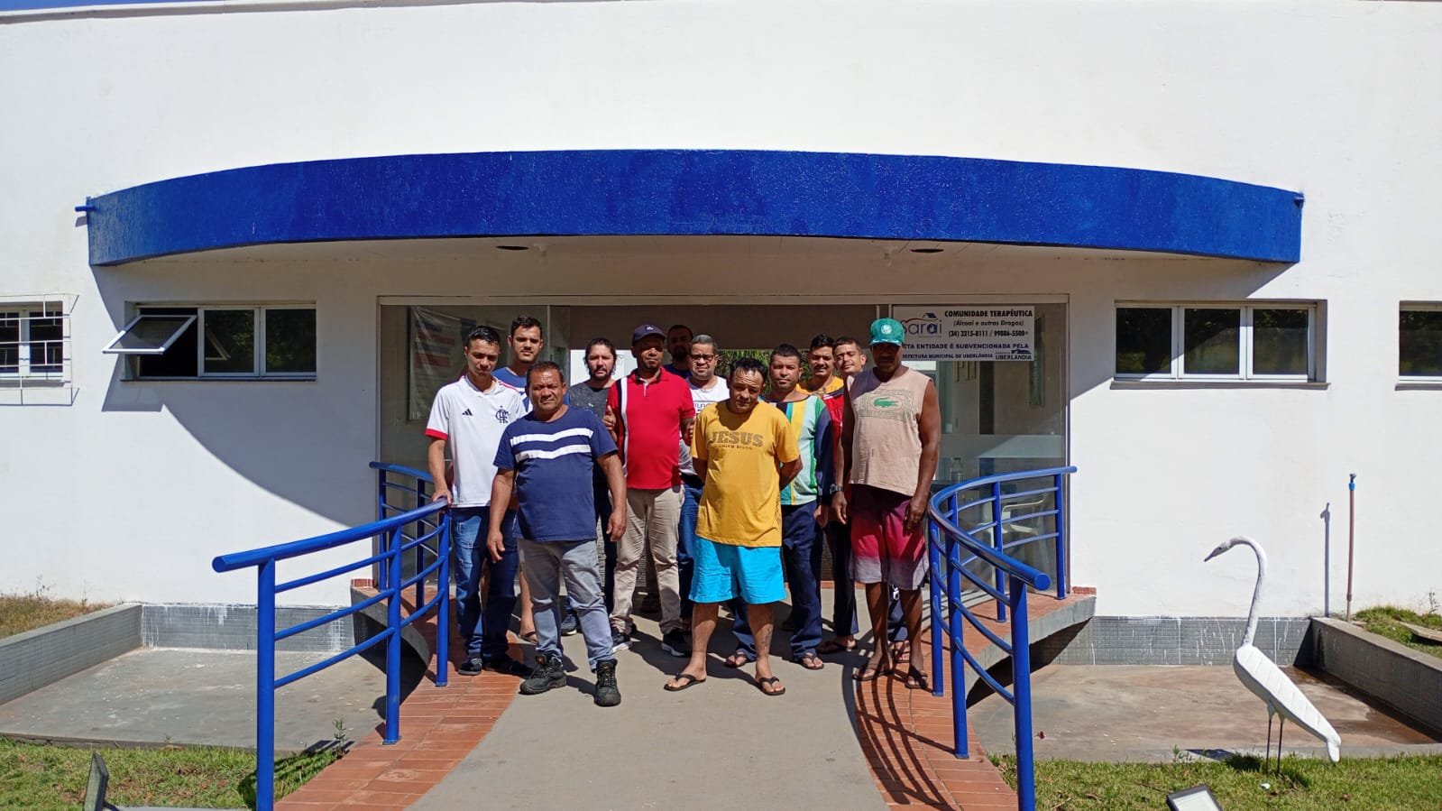Acolhidos e equipe em frente à unidade de acolhimento do Grupo Sarai